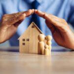 Hände schützen ein Modellhaus und Figuren, die eine Familie darstellen – Symbol für den Schutz der Mieterrechte 2024 durch die Kanzlei Ra-Hartung.