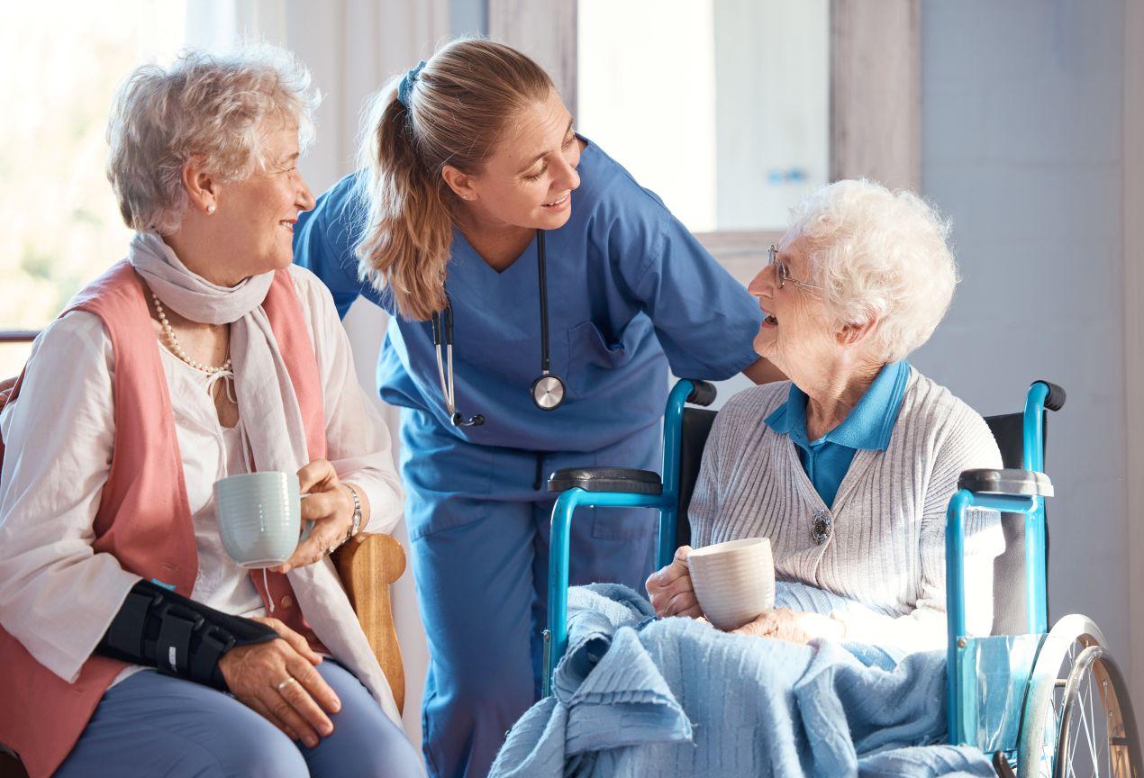 Pflegekraft im Gespräch mit zwei Seniorinnen im Wohnbereich – Pflegedienst Ahlen mit persönlicher Betreuung