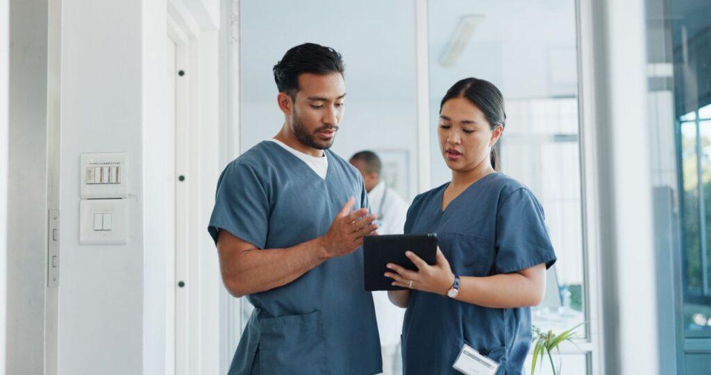 Zwei Pflegekräfte koordinieren Tagesablauf mit Tablet – Teamarbeit beim Pflegedienst Ahlen