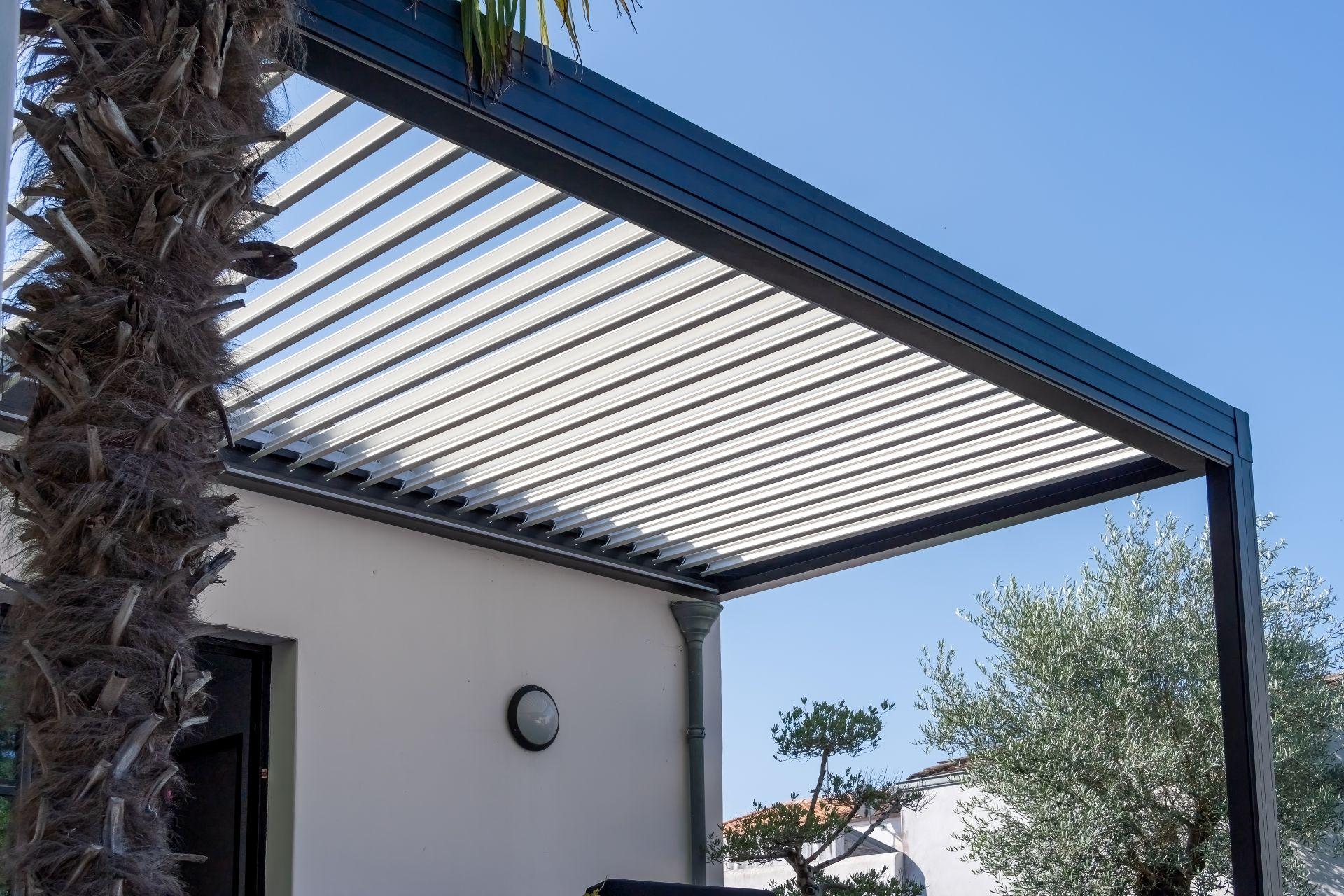 Hochwertige Lamellenüberdachung an moderner Terrasse mit klarer Linienführung und mediterraner Bepflanzung